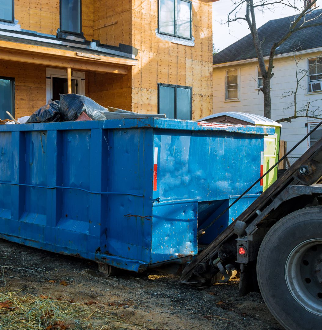 Construction site with blue dumpster container.